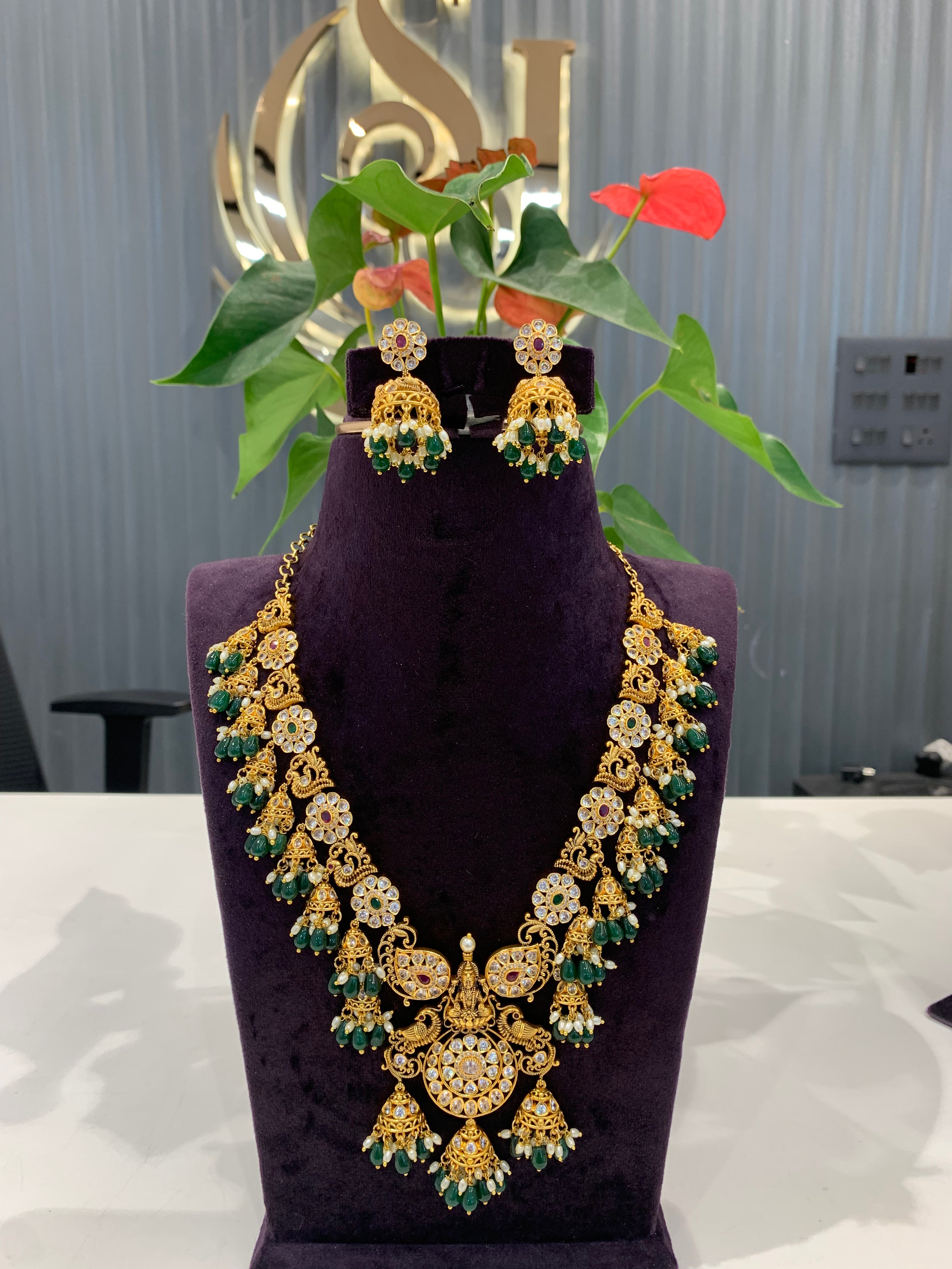 Beautiful peacock floral design necklace and  jumkis with green beads